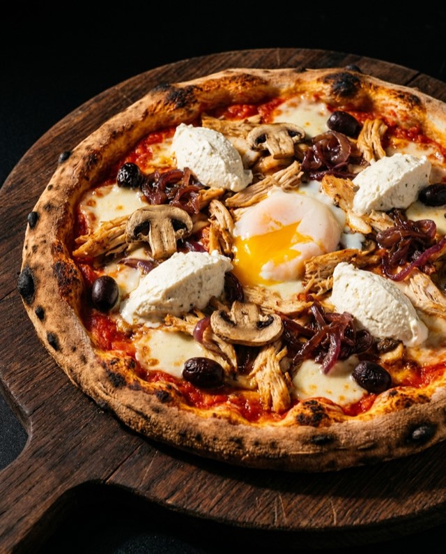 Pizza La Bonnevalaise : chèvre, champignons et œuf, sortie du four à bois